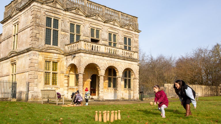 A picture of a family playing on the lawn in front of Lodge Park